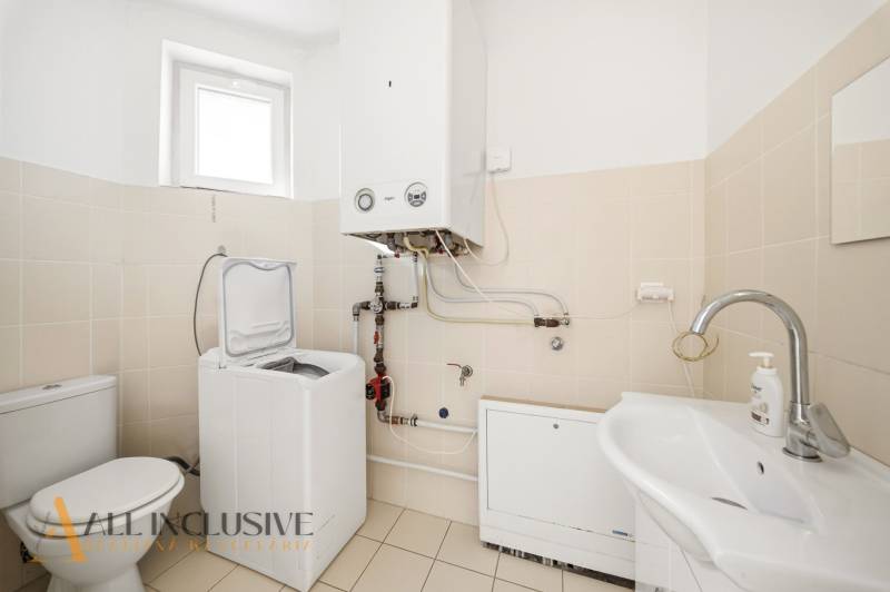 Badezimmer in einem Einfamilienhaus mit Speicher, Waschmaschine und Waschbecken.