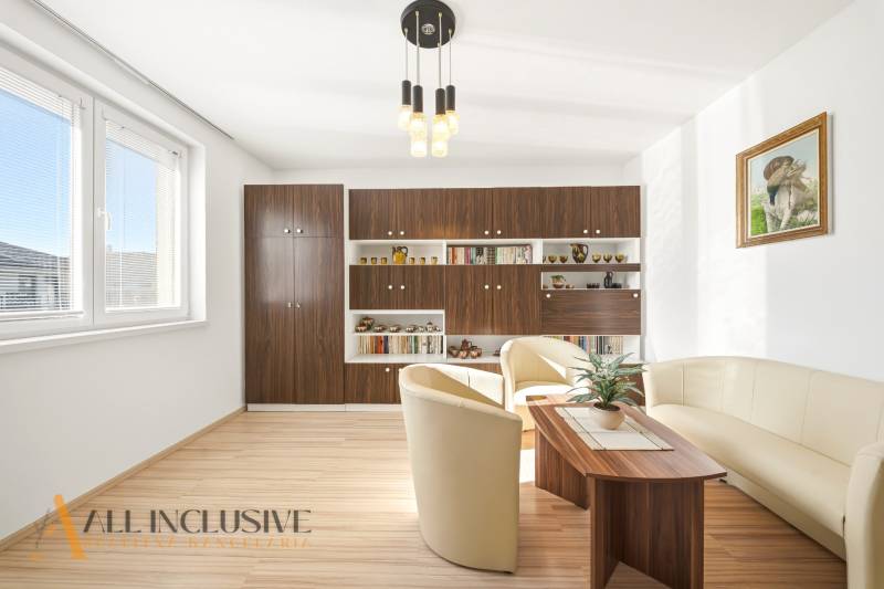 Wohnzimmer in einem Einfamilienhaus mit Holzboden und bequemen Sitzgelegenheiten.