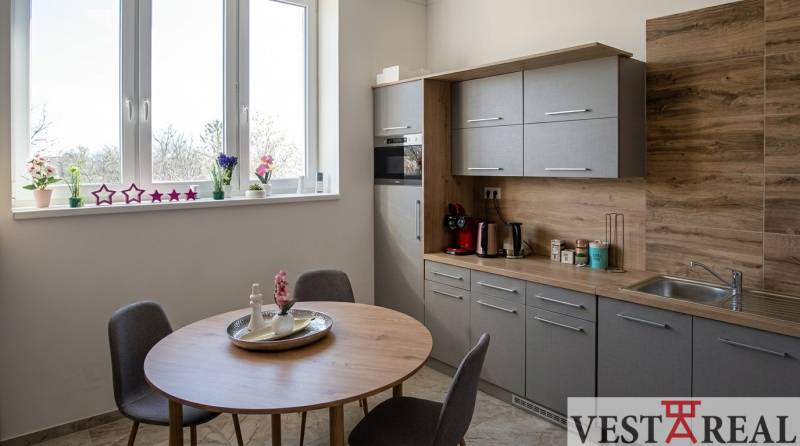 Küchenecke in Büros mit Fenster, Holzelementen und Esstisch.