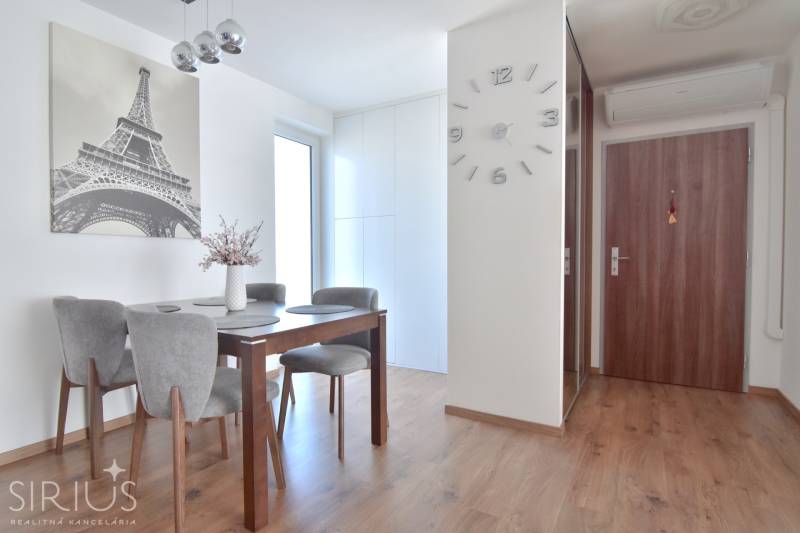 Essbereich in einer 3-Zimmer-Wohnung mit Eiffelturm-Dekor und Holzboden.