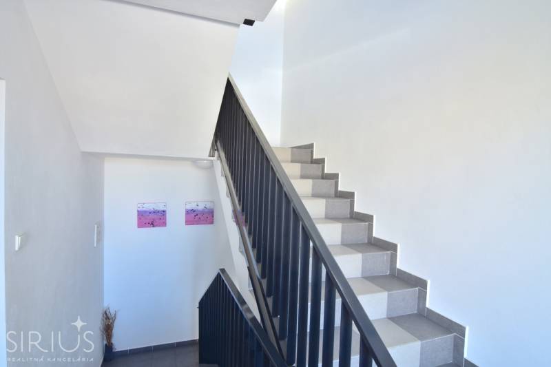 Eine Treppe mit weißen Wänden und Dekorationen in einer 3-Zimmer-Wohnung.