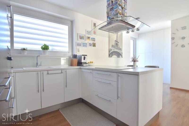 Küche in einer 3-Zimmer-Wohnung mit Eiffelturm-Dekor und Holzboden.