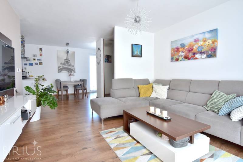 Wohnzimmer in einer 3-Zimmer-Wohnung mit Sofa, Dekorationen und Holzboden.