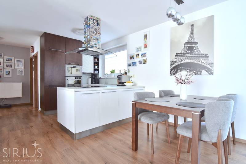 Küche in einer 3-Zimmer-Wohnung mit Holzboden und Esstisch.