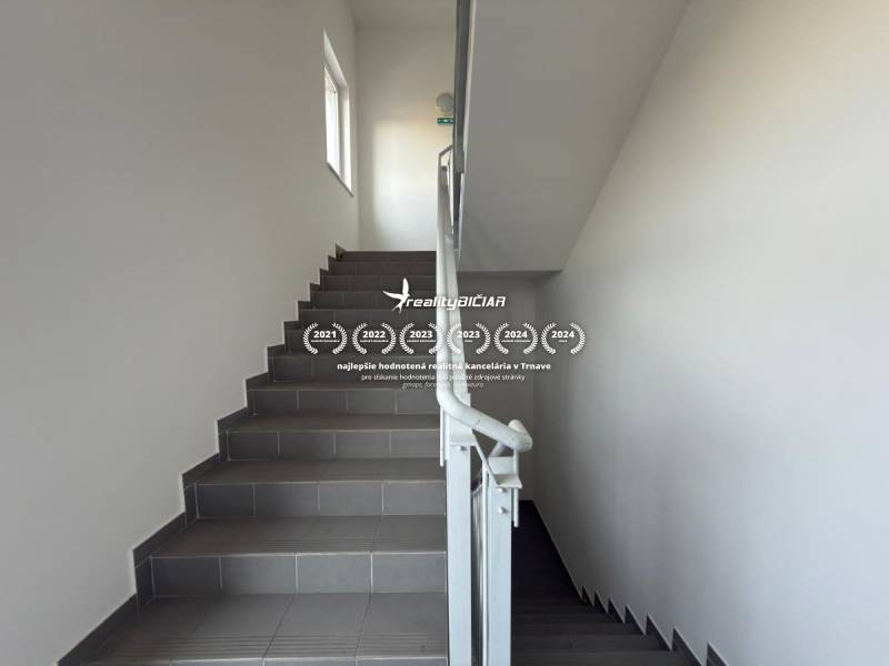 Flur mit Treppenhaus in besonderen Immobilien, graue Treppen, weiße Wände, Geländer.