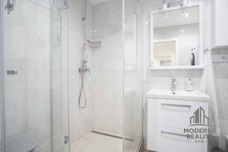 Badezimmer mit Dusche und Waschbecken in einer Zweizimmerwohnung.