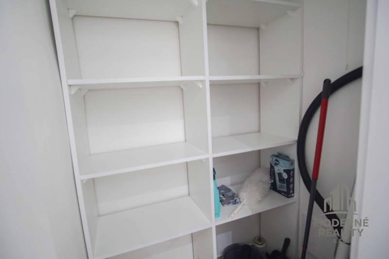 Stauraum mit weißen Regalen in einer 2-Zimmer-Wohnung.