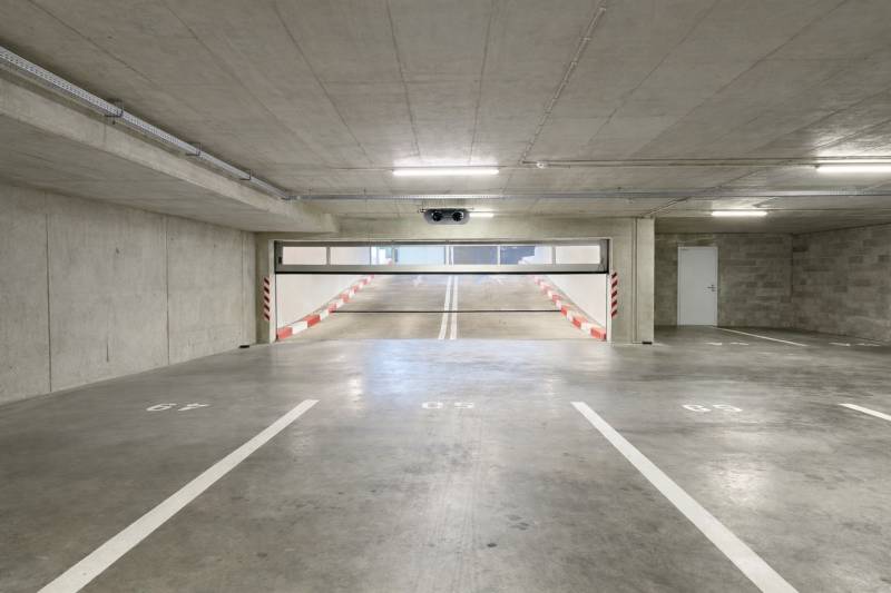Parkplätze in Garagen mit Rampe und weißer Markierung.