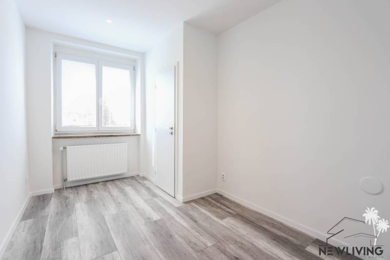 Helles Zimmer mit Holzboden und Fenster in einer 3-Zimmer-Wohnung.