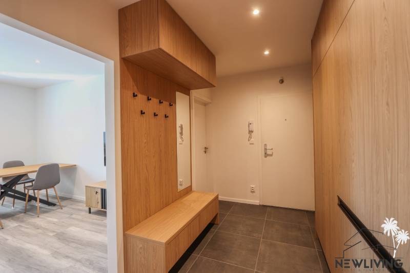 Eingangsbereich einer 3-Zimmer-Wohnung mit Fliesenboden und Holzelementen.