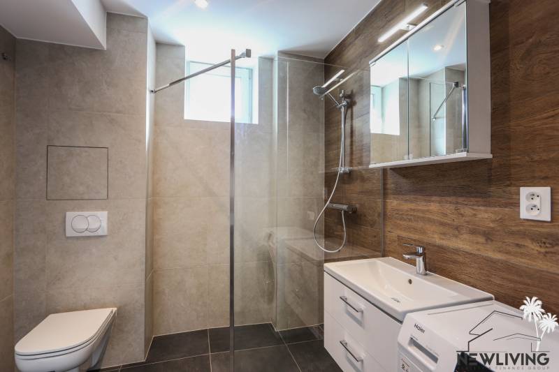 Badezimmer in einer 3-Zimmer-Wohnung mit moderner Sanitärausstattung und einem Boden in Holzoptik.