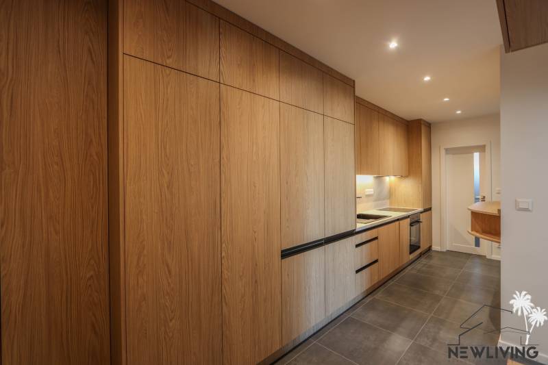 Küche in einer 3-Zimmer-Wohnung mit Holzboden und eingebauten Geräten.