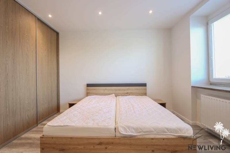 Schlafzimmer in einer 3-Zimmer-Wohnung mit Bett und Einbauschrank mit Holzdekor.