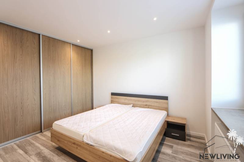 Schlafzimmer in einer 3-Zimmer-Wohnung mit Holzboden und einem großen Einbauschrank.