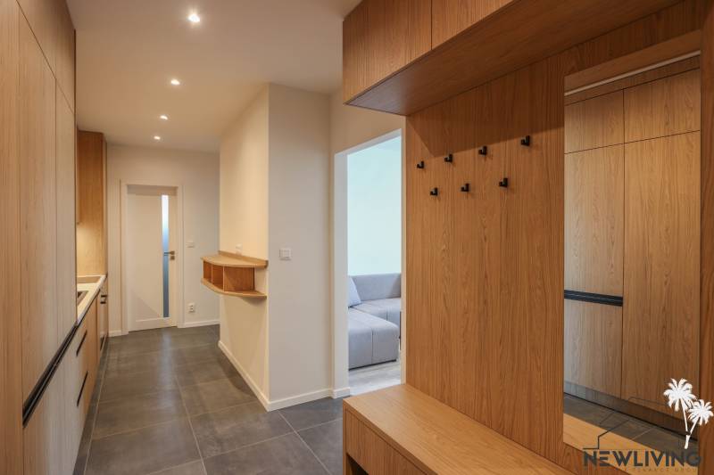 Flur mit Holzboden und Kleiderschränken in einer 3-Zimmer-Wohnung.