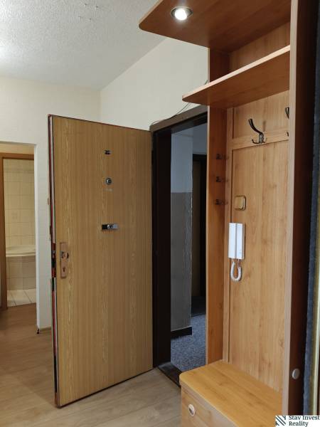 Eingangsbereich in einer 3-Zimmer-Wohnung mit Holzboden und Garderobenwand.