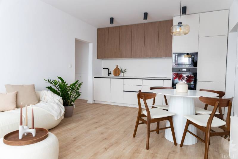 Wohnzimmer mit Küche in einer 3-Zimmer-Wohnung mit Holzboden.