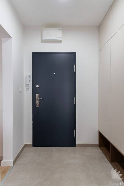 Eingangsbereich in einer 3-Zimmer-Wohnung mit dunklen Türen und Fliesen.