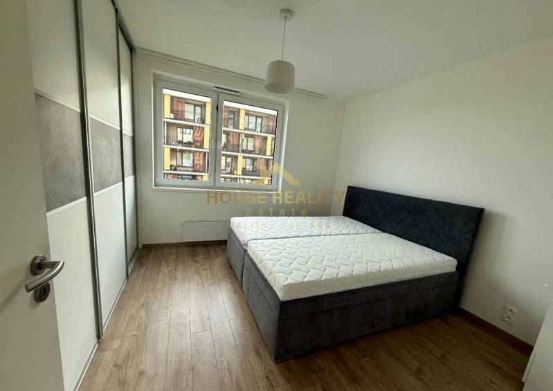 Schlafzimmer mit Einbauschrank, Doppelbett und Holzboden in einer Zweizimmerwohnung.