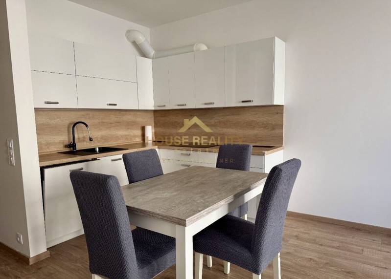 Küche in einer 2-Zimmer-Wohnung mit weißen Schränken und einem Boden in Holzoptik.