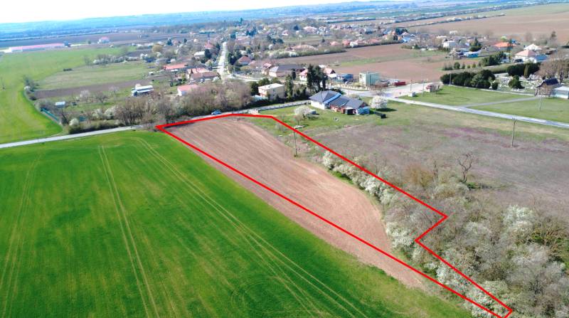 Luftaufnahme einer landwirtschaftlichen Fläche in Ondrejovce, umgeben von Gärten und dem Dorf.