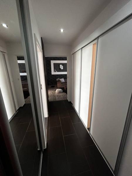 Der Flur in der 3-Zimmer-Wohnung mit dunklem Boden und Einbauschränken.