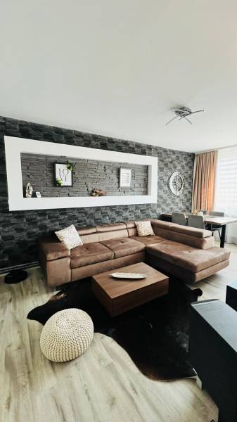 Wohnzimmer in einer 3-Zimmer-Wohnung mit Holzboden und Ecksofa.