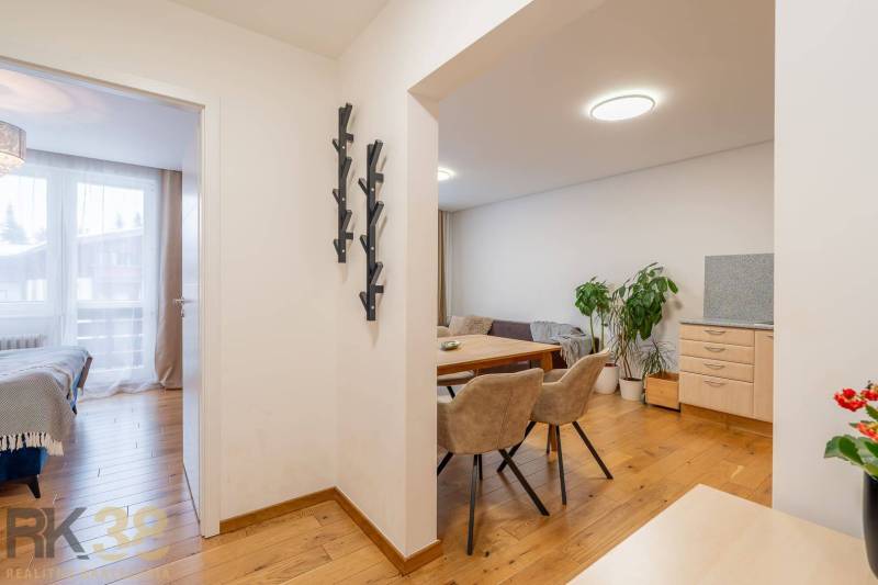 Innenraum einer Ferienwohnung mit Holzboden, Essbereich und Schlafzimmer.
