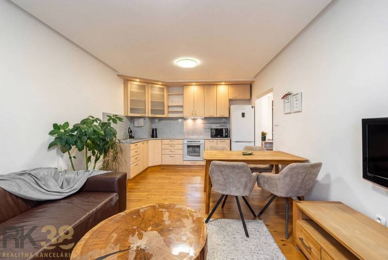 Wohnzimmer mit Küchenzeile in einer Ferienwohnung und einem Boden mit Holzdekor.