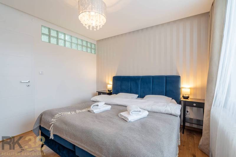 Schlafzimmer im Ferienapartment mit Doppelbett und Holzboden.