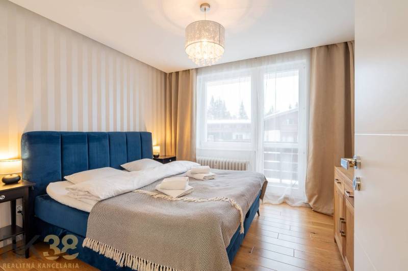 Schlafzimmer im Ferienapartment mit bequemem Bett und Boden in Holzoptik.