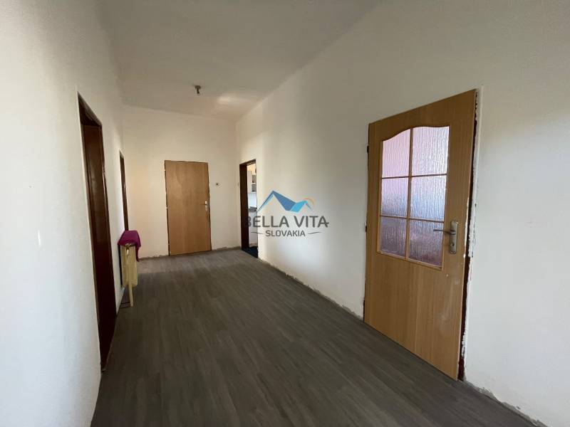 Chodba v rodinnom dome s podlahou s dreveným dekorom a drevenými dverami.