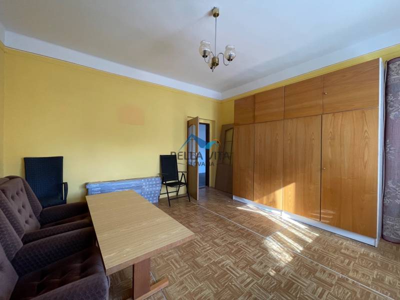 Obývacia izba s podlahou s dreveným dekorom, nábytkom a kreslami v rodinnom dome.