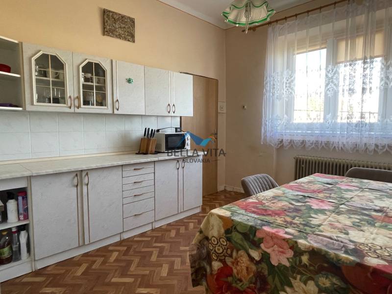 Kuchyňa s podlahou s dreveným dekorom v rodinnom dome.