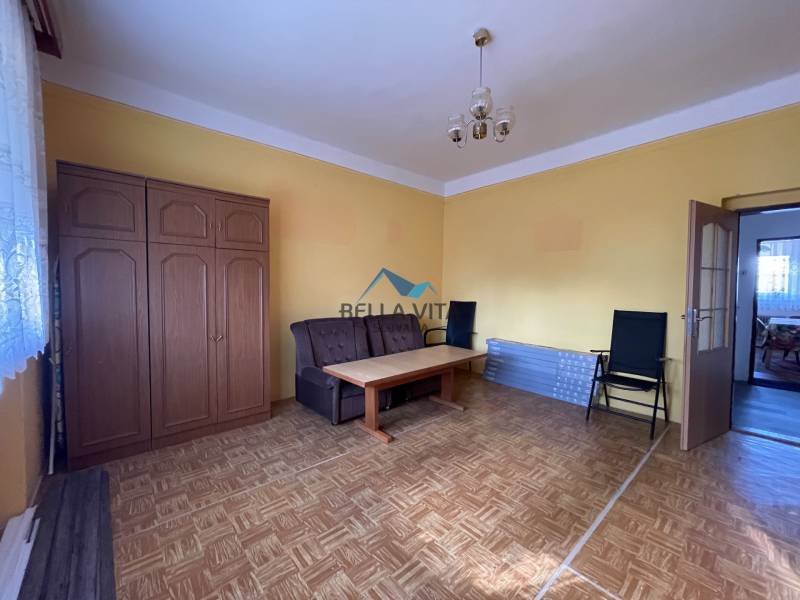 Obývacia izba v rodinnom dome s podlahou s dreveným dekorom a sedačkou.