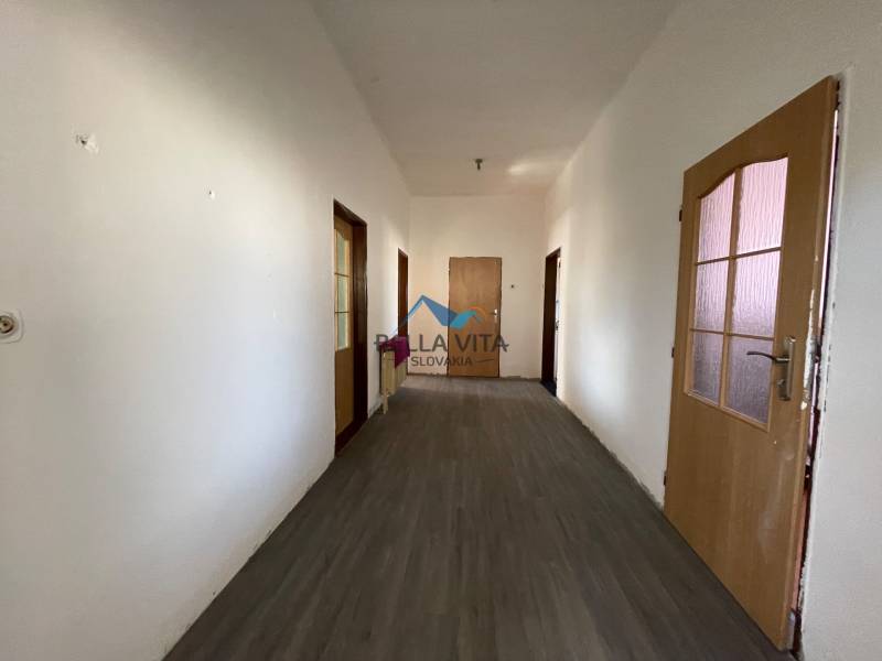 Chodba v rodinnom dome s podlahou s dreveným dekorom a dverami.