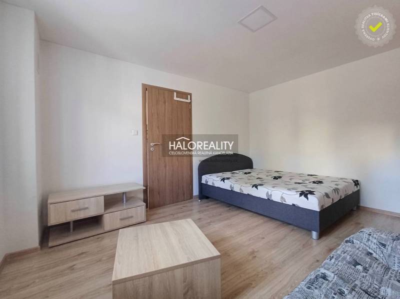 Einzimmerwohnung mit Bett und Möbeln auf einem Boden mit Holzdekor.