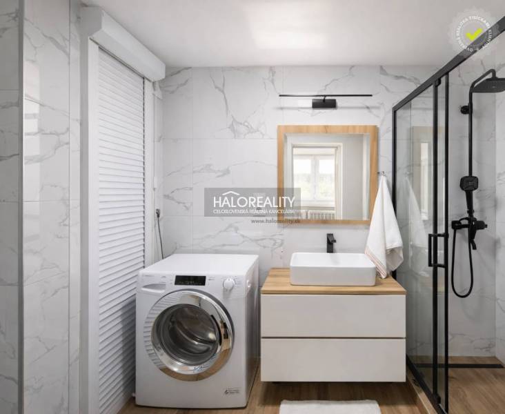 Badezimmer mit Waschmaschine, Duschkabine, Waschbecken und Boden mit Holzdekor in einer 4-Zimmer-Wohnung.