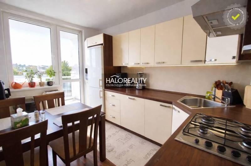 Küche in einer 4-Zimmer-Wohnung mit großem Fenster, Esstisch und hellen Möbeln.