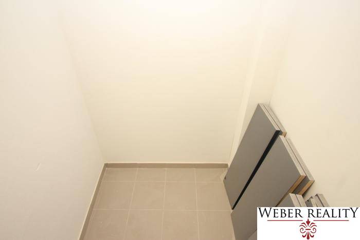 Ein kleiner Stauraum in einer Einzimmerwohnung mit Fliesenboden und weißen Wänden.