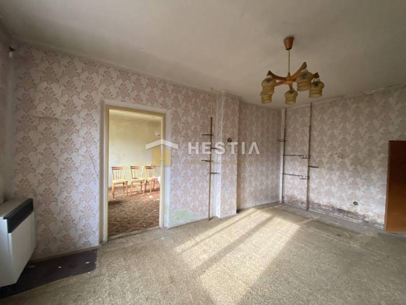 Ein Zimmer in einem Einfamilienhaus mit Blumenklebebildern, Teppichboden und einem Kronleuchter.