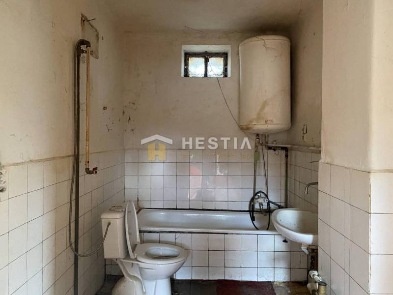Badezimmer in einem Einfamilienhaus mit Badewanne, Boiler und Toilette.
