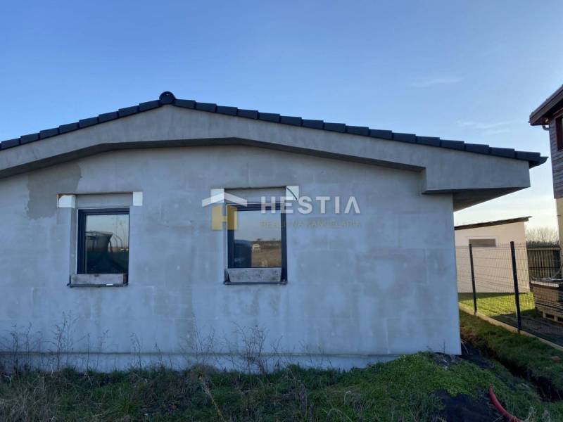 Einfamilienhaus in Sekule mit unvollendeter Fassade, Flachdach, zwei Fenster.