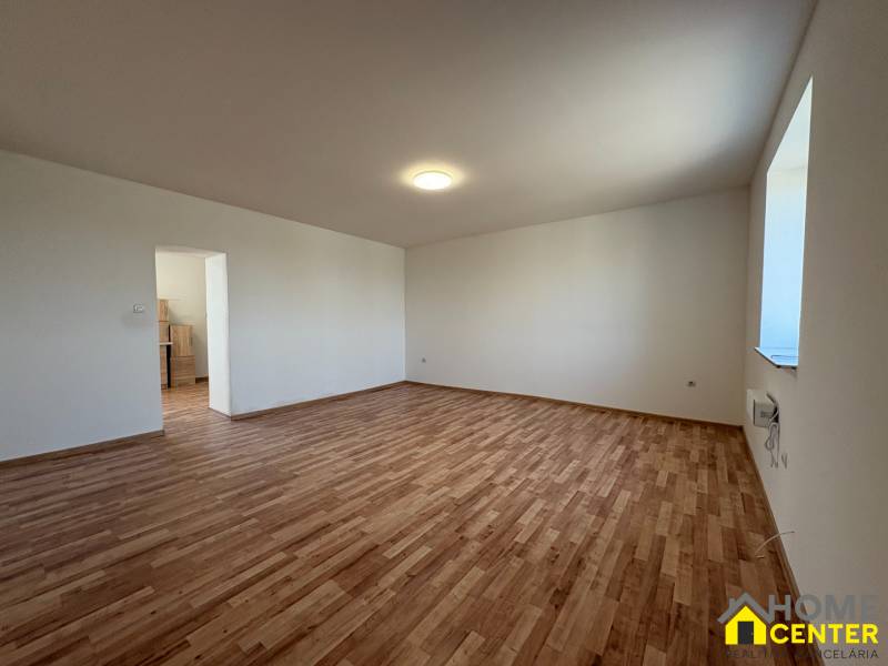 Ein Zimmer in einem Einfamilienhaus mit einem Boden in Holzoptik und weißen Wänden.