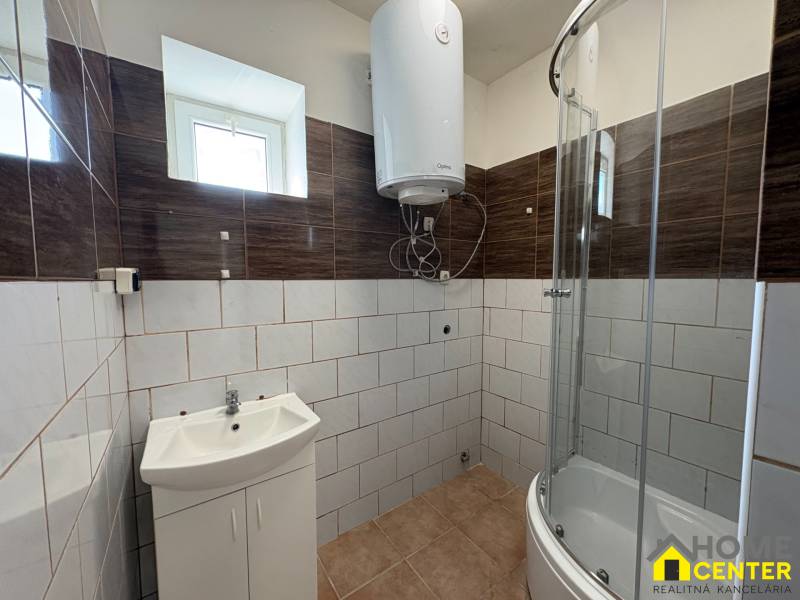 Ein Badezimmer in einem Einfamilienhaus mit einer modernen Dusche und hellen Fliesen.