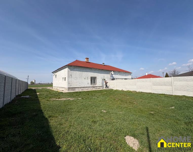 Ein Einfamilienhaus in Zemianska Olča mit weißer Fassade und rotem Dach auf einem grasbewachsenen Grundstück.