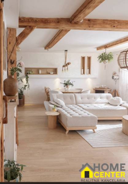 Wohnzimmer in einem Einfamilienhaus mit großem Sofa und Boden in Holzoptik.