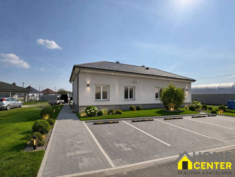 Ein Einfamilienhaus in Zemianska Olča mit Garten, Parkplatz und gepflastertem Gehweg.