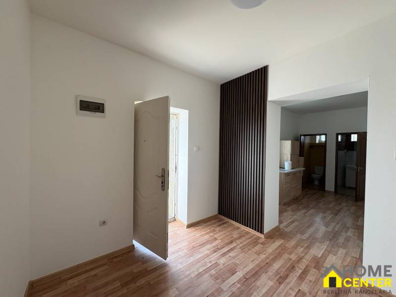 Ein Einfamilienhaus mit weißen Wänden und einem Boden in Holzoptik, geräumiger Eingangsbereich.