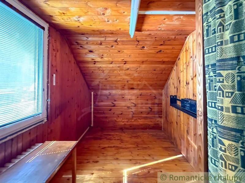 Ein Raum in einer Hütte mit einem Holzboden und einem Dachfenster.